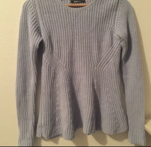  - Fin stickad tröja i "peplum" modell. Tröjan är en härlig ljusblå färg som var svår att fånga på bild. Sitter tightare i midjan & går utåt som en peplumtopp