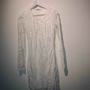  - Spetsklänning med snörning vid brösten. Tajt passform som ger fin figur. 