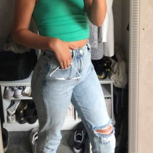  - Mom jeans med ett hål precis över knät 