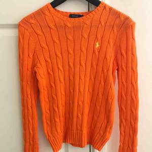 Klassisk, orange kabelstickad tröja från Ralph Lauren i bra skick. Använd ca 2 gånger. Jag möts upp i Stockholm eller köparen betalar frakten. Tar endast emot swish. 