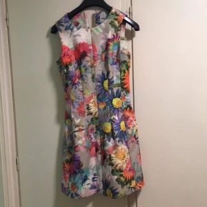 - Superfin blommig klänning i "scuba/hårt tyg" med fint fall! Säljer pga fel storlek. Frakt ingår ej. 