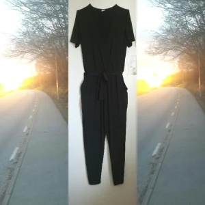 - Jumpsuit i stretchigt glansigt tyg från Gina Tricot. V-ringad, med knapp, fickor. Smått nopprig på baksidan, därav pris.