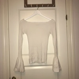  - En jättesnygg vit långärmad tröja med volangärmar i mycket bra skick! 