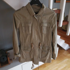  - Snygg vårjacka i militärstil. Knappt använd. Köparen står för frakten. 