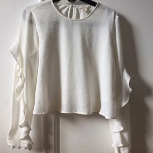  - Något croppad topp med volang på ärmarna 