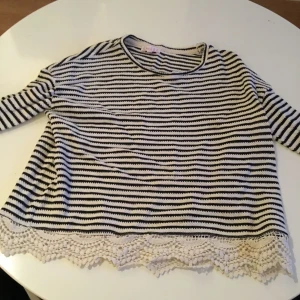  - En tröja i storlek 146/152 men är som en xs. Är svart vit randig med lite spets nertill. Köparen står för frakt.