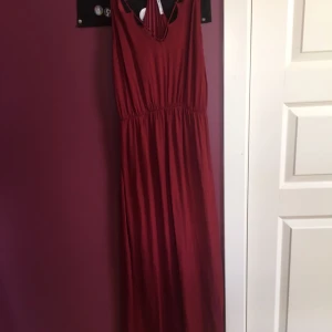  - Aldrig använd . Köptes i fel storlek. Bra material i vinröd färg med fin rygg och dekoration vid urringningen . 