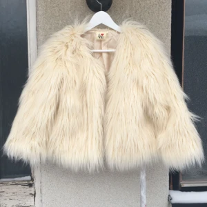  - Lite kortare fuskpälsjacka/cardigan. Finns en knapp i kragen. 