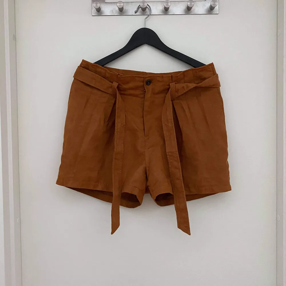Mörkt orangea shorts i mockaimitation (100% polyester) som knyts med midjeband. Jättebra skick, knappt använda. Ganska stora i storleken, passar 38a.. Shorts.