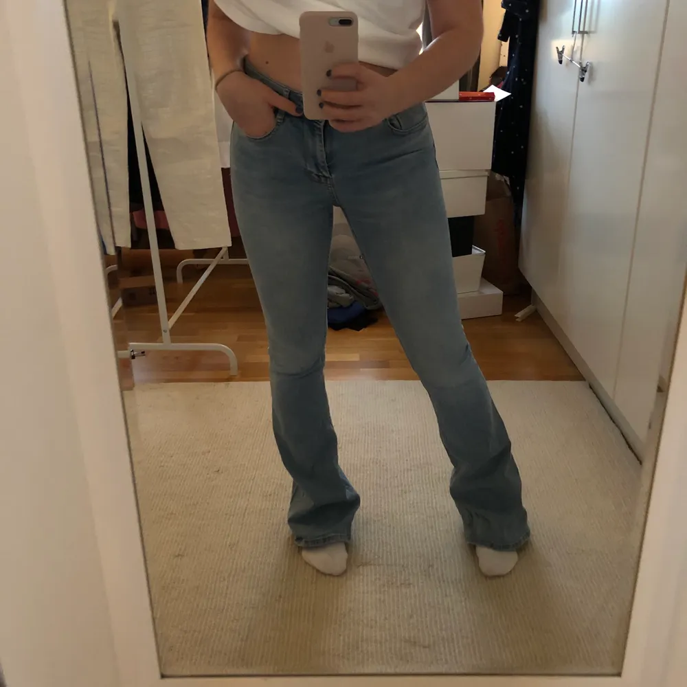Ett par låg-/mellanmidjade ljusblå flare/bootcut jeans från Zara. Använda men i bra skick! Stretchiga och formar sig fint efter kroppen. Jag på bilden har normalt 38 och är 168 cm med långa ben 💙. Jeans & Byxor.