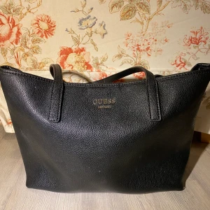 Guessväska - Svart läderväska, fint skick. Insidan är leopard.