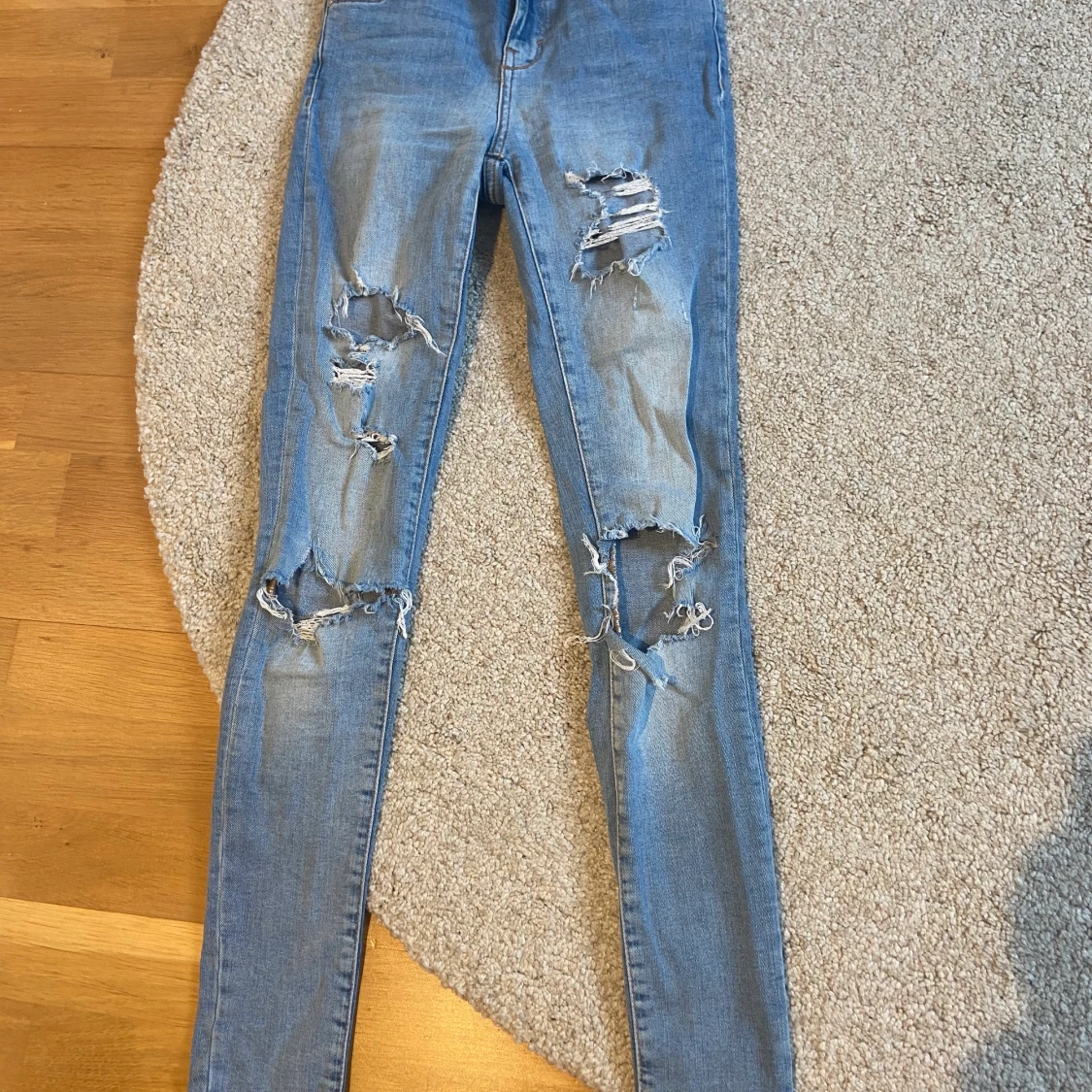 Blåa jeans me hål
