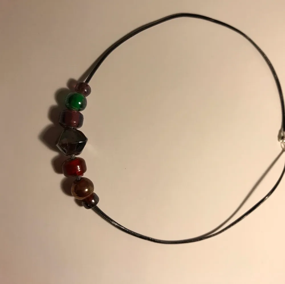 Ett svart halsband med olika pärlor/stenar i olika färger:)). Accessoarer.
