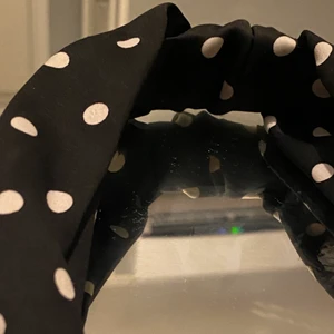 Hårband - Svart hårband med vita prickar samt en Knut mitt på bandet. Använd cirka 4 gånger under korta perioder, väldigt fint skick! Köpt på hm för ett tag sen men ångrade köpet sedan