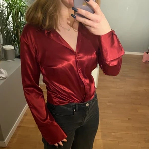 Vinröd silkig blus - Vinröd, glänsig blus med coola ärmar! Superfin att  knyta, stoppa in eller ha under något.