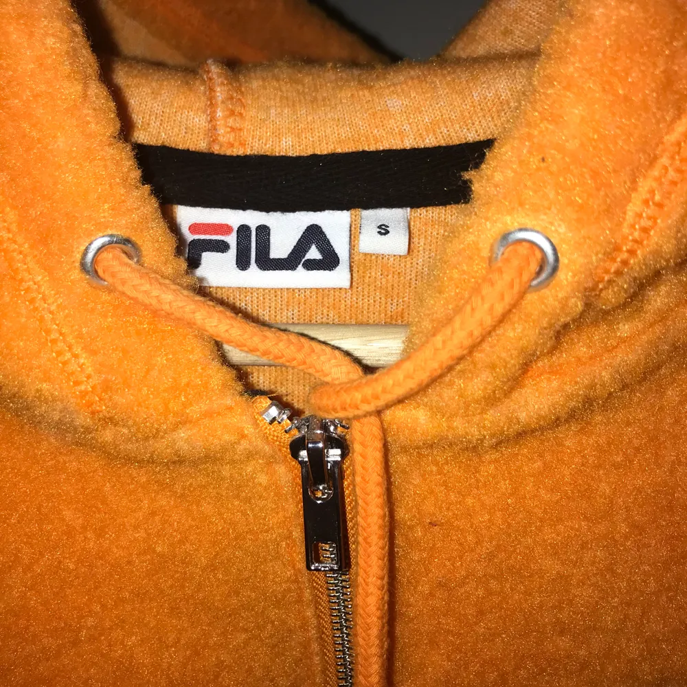 Neon orange fleece från en limited edition kollektion från FILA köpt på Junkyard. Den är knappt använd och i stl S. Avklippt till vad som på mig (164cm) är strax under naveln. . Hoodies.