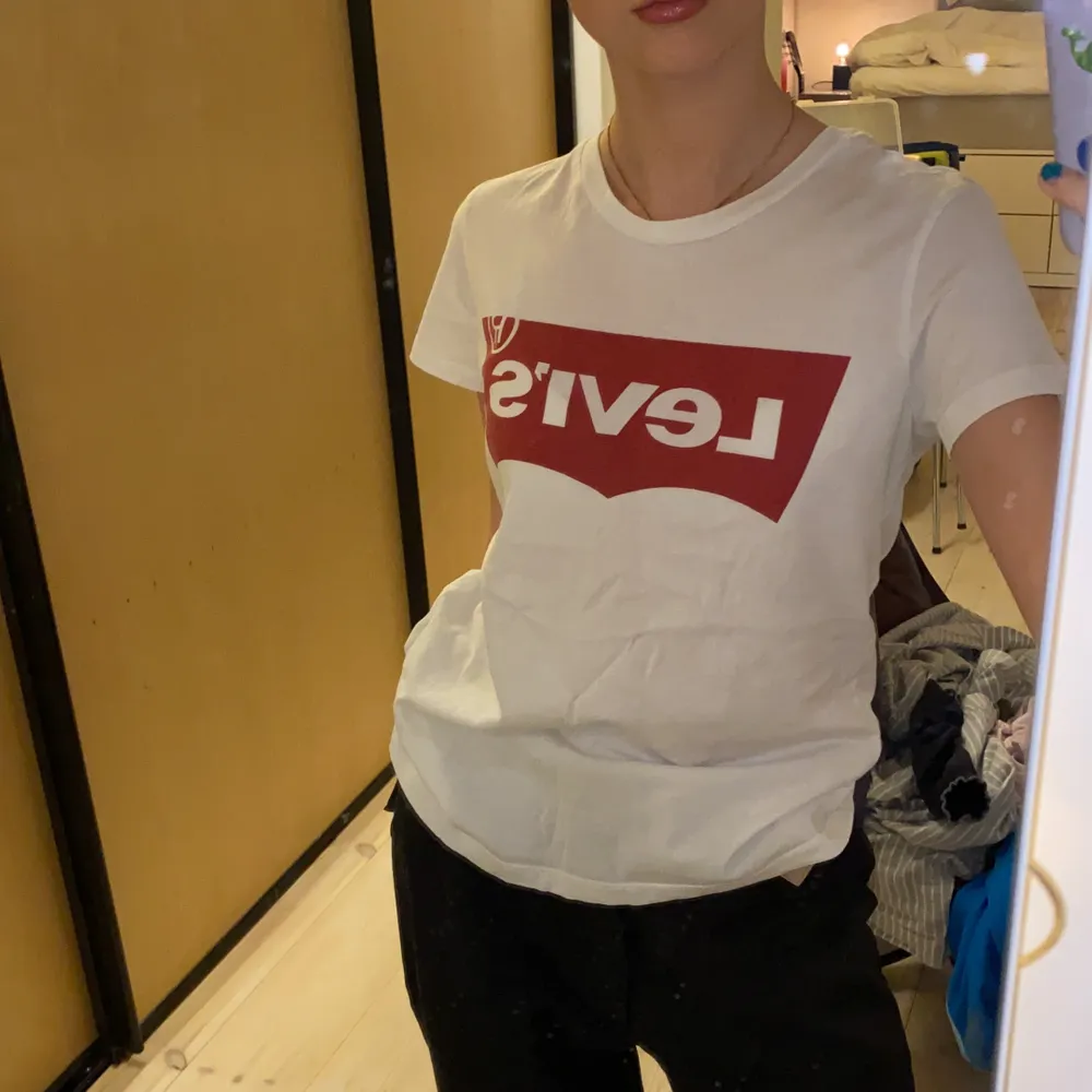 Vit fin mjuk Levis t-shirt med stort rött Levis märke fram.❤️🤍 Mycket bra skick, då den endast är använd ett fåtal gånger och tvättad kanske en eller två gånger. Material 100% bomull. (Säljer pga för liten och inte riktigt min stil längre). Jättefin, jättemjuk, bekväm och snygg till tex jeans. Storlek XS så på mig som är XS/S är den lite liten, men om man vill att den ska vara taight så är den ganska lagom. (Se hur den sitter på mig på första bilden). DM vid intresse/frågor/fler bilder.❣️(Det kan du göra här under där det står ”kontakta”). Avhämtning på Södermalm eller frakt till självbetalningspris.:). T-shirts.