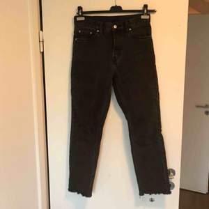 Svarta/grå jeans från Weekday. Modell ”Line washed black” i storlek W27 L28. Hög midja, fransiga nere