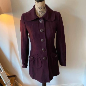 Snygg lila kappa för 30kr - Snygg plommonfärgad/lila jacka från MQ Stockholm. Passar till vintern och sen höst samt tidig vår. Använd men i fint skick.