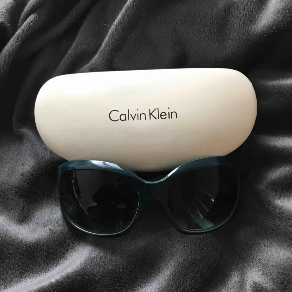 Calvin Klein solglasögon i turkos med svart glas o silver detaljer. Kommer med original skydd. Inga repor eller defekter.. Accessoarer.