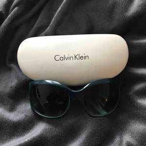 Calvin Klein solglasögon i turkos med svart glas o silver detaljer. Kommer med original skydd. Inga repor eller defekter.