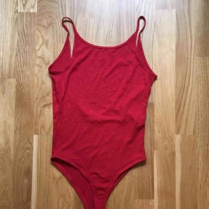  - Röd body från Pull and Bear, låg i ryggen och endast använd några gånger så i mycket bra skick. Kan mötas upp i stockholm eller skicka, köpare står för frakt.