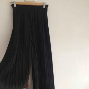  - Snygga plisserade byxor med snöre runt midjan! Snöret kan tas av. Ingen storlek markerad, men är extremt stretchig runt midjan, och bältet kan även dra in midjan. Därför passar det alla storlekar! Oerhört skönt material och luftigt.