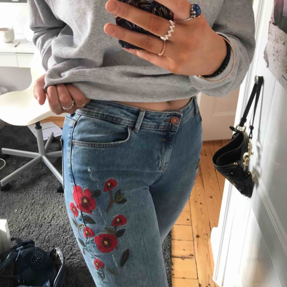 Supervåriga jeans från Zara. De är ljusblå med röda broderade blommor på vardera sida om höften:) Även lite slitna i den ljusblå färgen!. Jeans & Byxor.