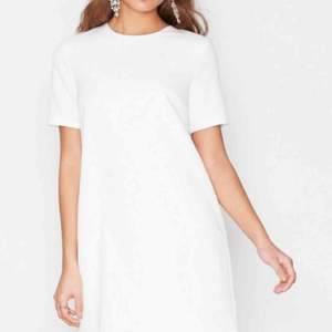 Slutsåld och oanvänd vit t-shirt klänning i modellen ”Flirt me” från Nelly i storlek 36. Superfin till studenten!  Eventuell frakt tillkommer på 36kr.