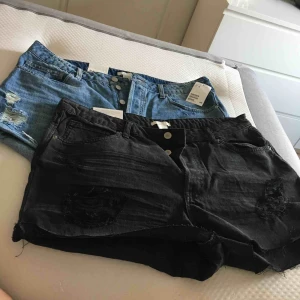  - 2 par jeansshorts, ett par blåa och ett par svarta. Lite slitna och hög modell. Lite små i storleken, mer som strl 42-44.