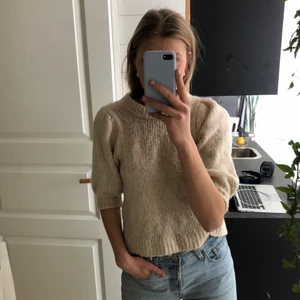 Beige stickad  - Säljer en beige-stickad tröja från Gina tricot med korta ärmar, skön och mysigt samtidigt som den är stilren💫🤍