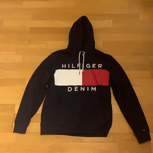 Tommy Hilfiger hoodie (Marin blå) - En marinblå Tommy Hilfiger hoodie köpt i USA.          Ett år gammalt och litta använd är den allt, men va fan syns inte ens :)