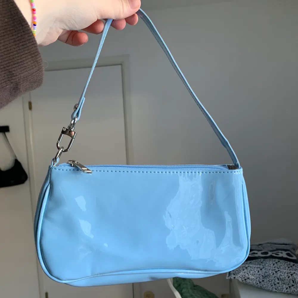 En blå väska i lackat material som jag köpt här på Plick! Var för liten för min smak men hoppas den kan glädja någon annan 💖 Frakten går på 57:-. Väskor.
