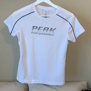 Peak performance träning t-shirt  - Vit T-shirt i stretchigt material. Ganska liten till storleken. 