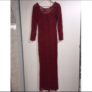  - Elegant vinröd maxiklänning i spets. Djup V-ringning bak. Oanvänd.
(Har den även i svart)