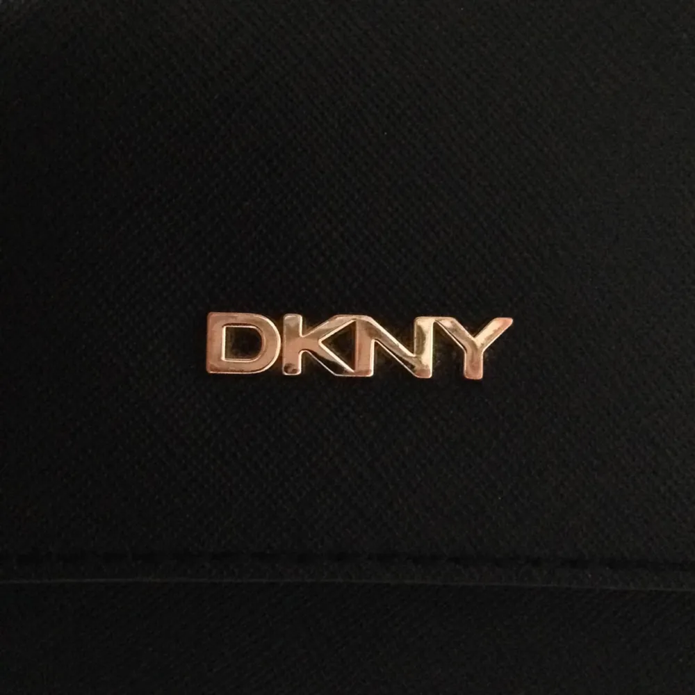 Väska från DKNY, perfekt storlek! Justerbar rem och mäter ca 20x30cm. Små förslitningsskador främst på metalldelarna men all in all i väldigt bra skick. 
Frakt ok men då står du för det:)). Väskor.