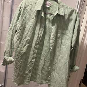 En fin lite oversize skjorta i ljusgrön o vit. Sitter bra. Är från monki och endast använd 1 gång 