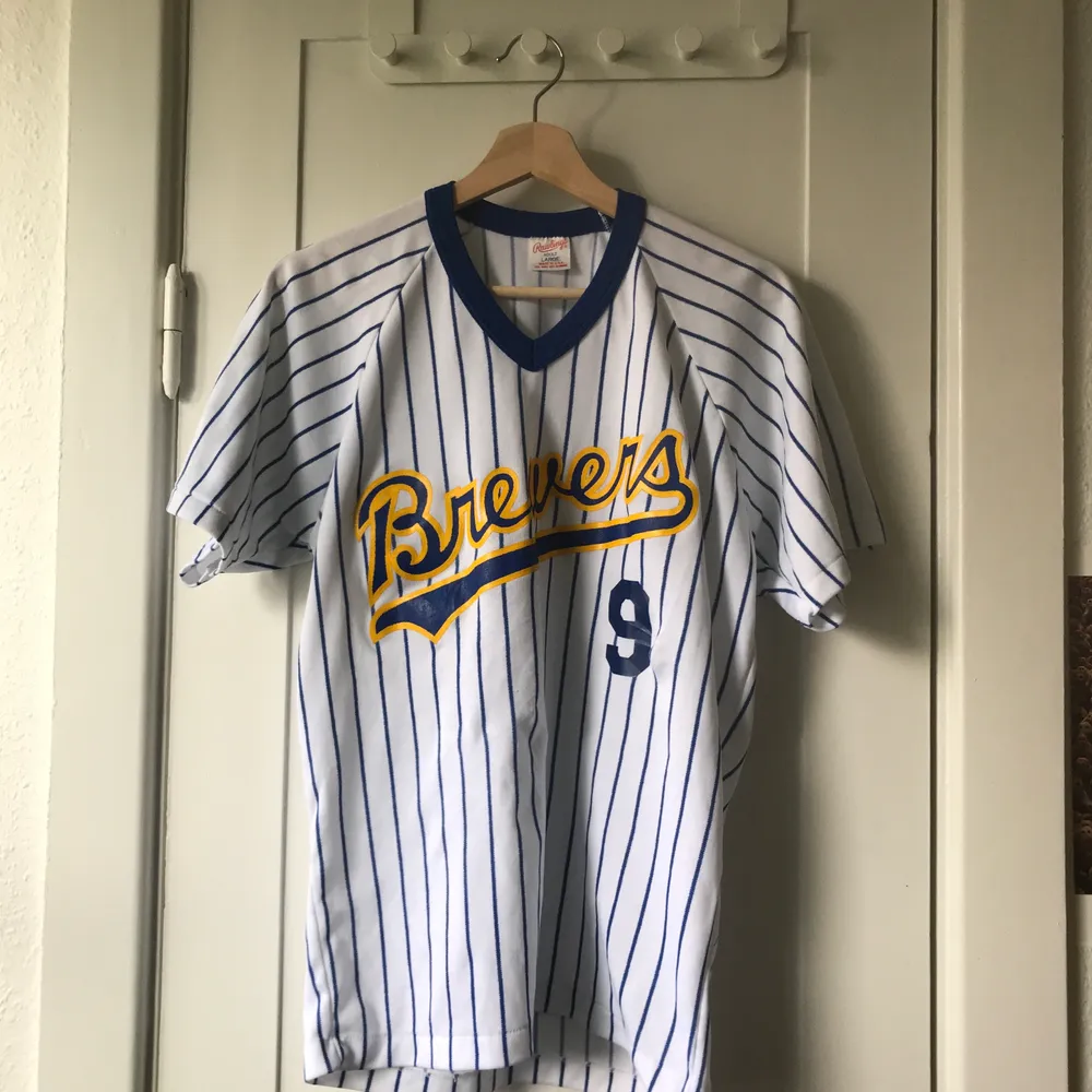 Cool vintage baseballtröja med texten ”Brewers 9” på framsidan. Storlek: ”adult L”. Vit med blåa ränder.. T-shirts.