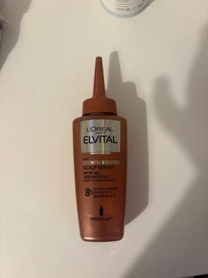 L'Oréal Elvital Growth Booster Serum - L'Oréal Paris Elvital Growth Booster Scalp Serum i kopparfärgad plastflaska med smal applikator. Innehåller 102 ml och är berikad med 8% komplex och Aminexil för att stärka håret och minska håravfall. Perfekt för dig som vill boosta hårväxten.