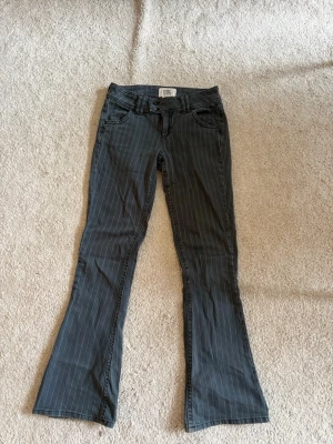 Gråa bootcut jeans med ränder  - Snygga gråa bootcut jeans från Urban Outfitters med tunna vita vertikala ränder. Klassisk femficksmodell och låg midja. Jeansen har utsvängda ben och är perfekta för en trendig och avslappnad look.💕💕💕