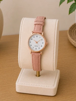 Rosa klocka med mockaband - Stilren klocka med rund vit urtavla, roséguldfärgat boett och rosa mockaband. Urtavlan har tydliga svarta siffror och tunna visare i roséguld. Perfekt accessoar för dig som gillar en enkel men snygg look.
