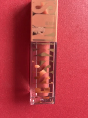 Maybelline City Sizzle blush  - Snyggt flytande blush and gloss  från Maybelline i färgen 06 City Sizzle. Kommer i en genomskinlig fyrkantig tub med persikofärgat lock. Ger en intensiv och trendig färg med glansig finish. Perfekt för dig som vill ha en modern look.