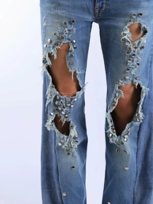 Unika lågmidjade baggy bootcut jeans med silver detaljer - Jättefina och unika lågmidjade baggy jeans med slitningar och silvriga detaljer. Jeansen är bootcut och har fina detaljer.   - Storlek: S - Midjemått: 42 cm  - Innerbenslängd: 79,5 cm  - Ytterbenslängd: 101 cm - Modellen är 175 cm lång för referens  Jeansen är i jättebra skick och har inga defekter (vad vi märkt)!!  Vid frågor eller funderingar - tveka inte att höra av dig🪽