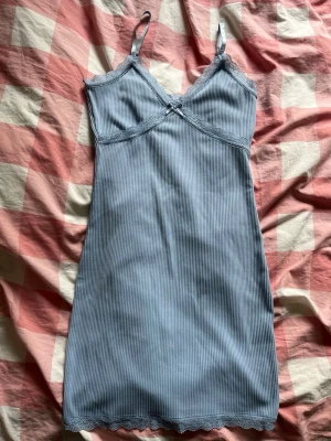Blå ribbad klänning  - Snygg klänning med vuringing och en roset med. Skriv om ni har frågor eller vill ha fler bilder!💞