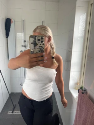 Vit ribbad tubtopp - Säljer tvä vita ribbade tubtoppar med stretchigt material och figurnära passform. Topparna har en enkel och stilren design utan axelband, perfekt för sommardagar eller att styla lager på lager. Passar till både jeans och kjol för en trendig look.  Köp två i en 