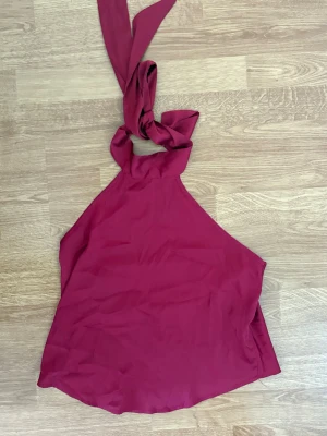 Mörkröd halterneck linnetopp med öppen rygg - Halterneck topp med öppenrygg, perfekt på sommaren. Använt 0 gånger så är i perfekt skick. Skickas inom 1-2 dagar.