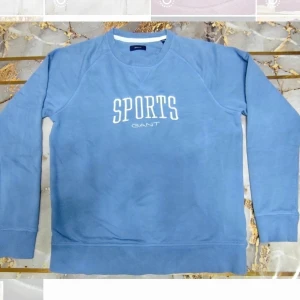 Blå sweatshirt från Gant  - Blå sweatshirt från Gant med vit text 'SPORTS' och logga framtill. 