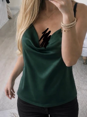 Mörkgrön satin linnetopp - Stilren mörkgrön linnetopp i satin med tunna axelband och snygg draperad urringning. Perfekt att matcha med jeans eller kjol. Toppens material har en vacker passform.