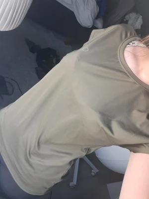 Grön kortärmad t-shirt från OTP - Snygg grön t-shirt från OTP i storlek XS. T-shirten har en enkel och avslappnad passform med rund hals och korta ärmar. Tillverkad i ett mjukt och lätt material som passar perfekt till träning eller chill dagar.