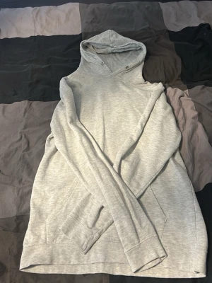 Ljusgrå hoodie från Studio Total - Säljer en ljusgrå hoodie från Studio Total i storlek M. Hoodien har en klassisk huva med metallöljetter och en stor magficka framtill. Tillverkad i mjukt bomullsmaterial och har långa ärmar med ribbade muddar. Perfekt för en chill och avslappnad stil.